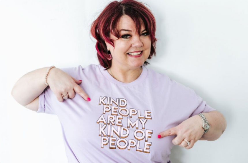A smiling woman with red hair points to her lavender T-shirt that reads "Kind people are my kind of people." She has painted nails and wears a bracelet and watch, perfect for a social media scheduler post | plannthat.com A smiling woman with red hair points to her lavender T-shirt that reads "Kind people are my kind of people." She has painted nails and wears a bracelet and watch, perfect for a social media scheduler post | plannthat.com