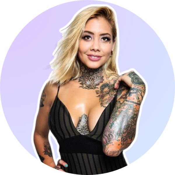 Woman with blonde hair and tattoos, wearing a black striped dress, posing with one hand on her shoulder against a light purple background, perfect for a social media planner | plannthat.com Woman with blonde hair and tattoos, wearing a black striped dress, posing with one hand on her shoulder against a light purple background, perfect for a social media planner | plannthat.com